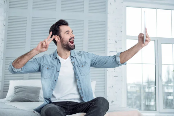 Positieve blij bebaarde man kijken naar zijn gadget — Stockfoto