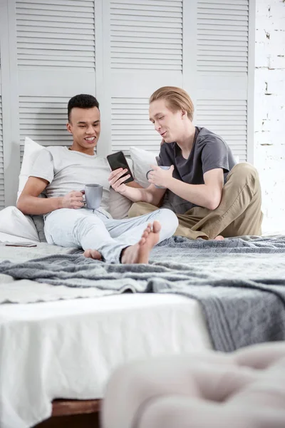 Alegre pareja gay lectura en línea artículo —  Fotos de Stock