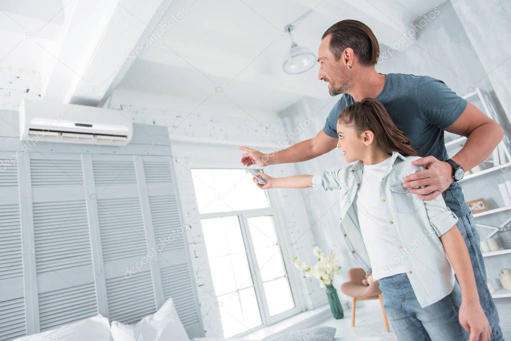 Positive joyful man pointing at the air conditioner