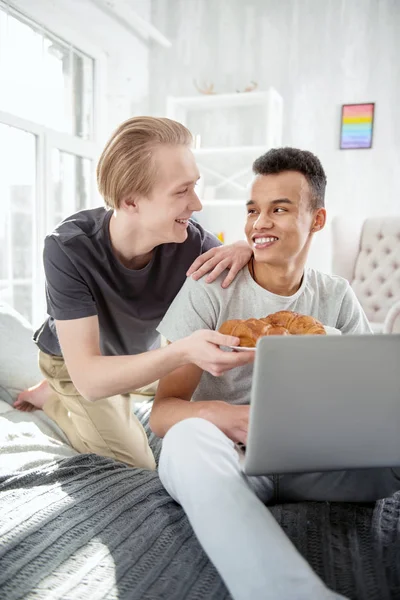 Feliz pareja gay consumiendo croissant — Foto de Stock