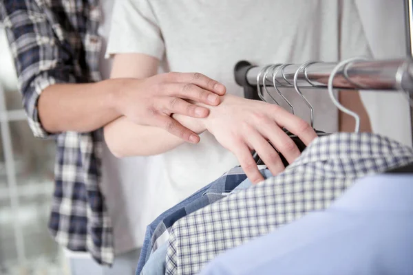 Jonge mannelijke handen tellen shirts — Stockfoto