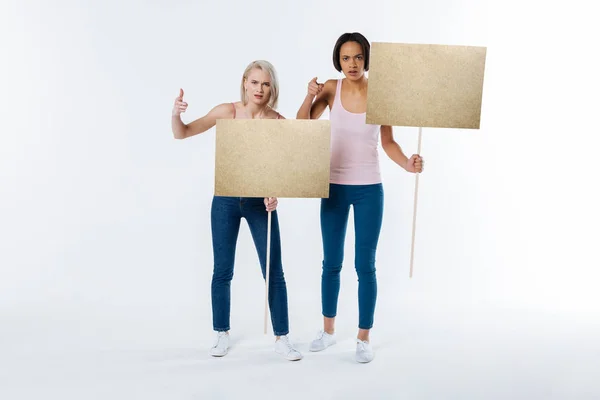 Serious nice women holding protest signs — Stock Photo, Image