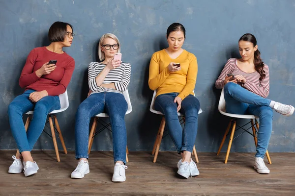 Mulheres bonitas atraentes segurando seus smartphones — Fotografia de Stock