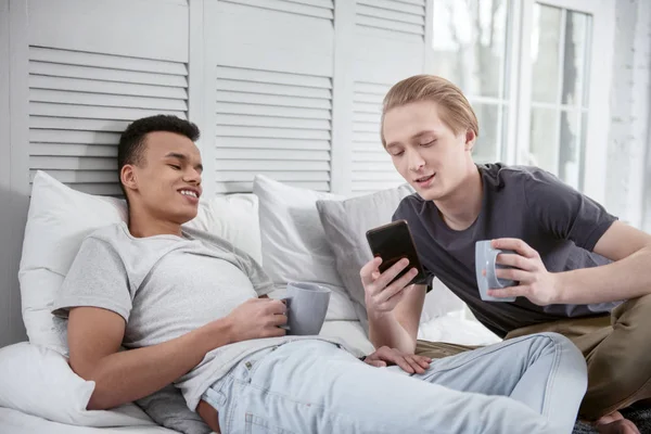 Musing gay couple regarder vidéo sur téléphone — Photo