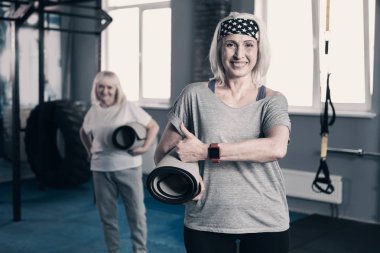 Yaşasın vererek yoga mat ile atletik üst düzey kadın