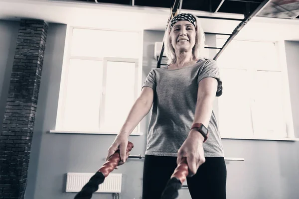 Mujer mayor bien construida sosteniendo cuerdas de batalla — Foto de Stock