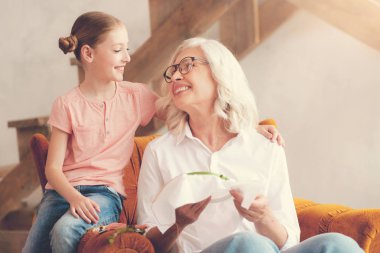 Torunu için gülümseyen güzel yaşlı kadın