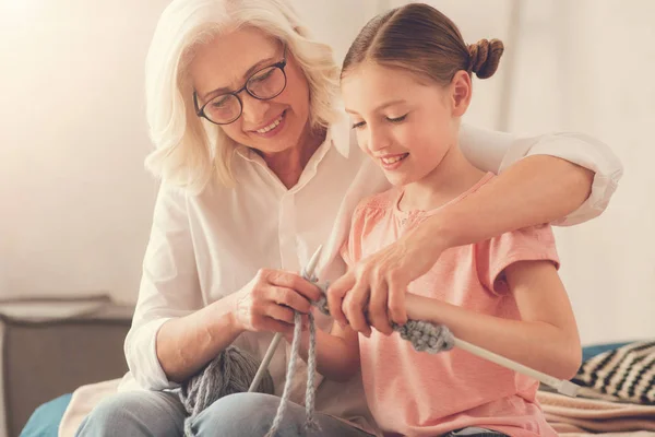 Mujer anciana agradable enseñando a su nieta a tejer —  Fotos de Stock