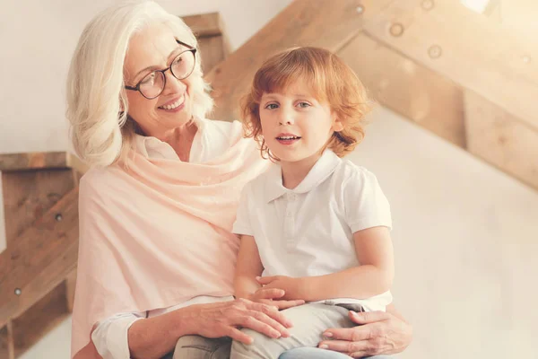 Delighted aged woman holding her grandson — Stock Photo, Image