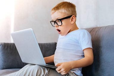 Dizüstü bilgisayar ekranına bakarak iyi duygusal çocuk