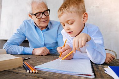 Positive nice grandfather helping his grandson clipart