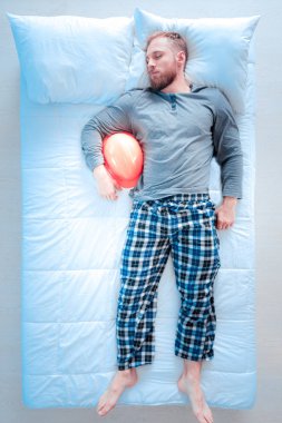 Sakallı adam balon tutarak yorgun