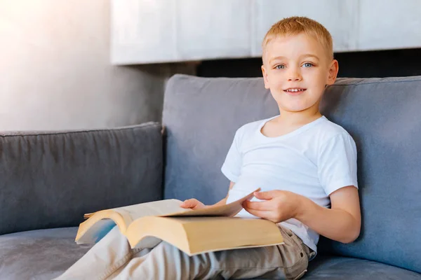 Trevlig smart pojke håller en bok — Stockfoto