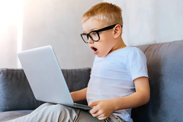 Bel ragazzo emotivo guardando lo schermo del computer portatile — Foto Stock