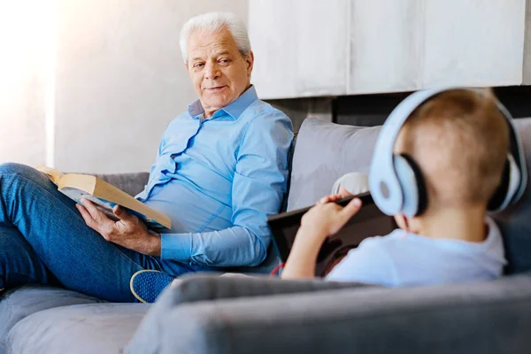 Feliz hombre alegre sentado junto con su nieto —  Fotos de Stock