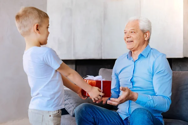 Agradable chico dando un regalo a su abuelo —  Fotos de Stock