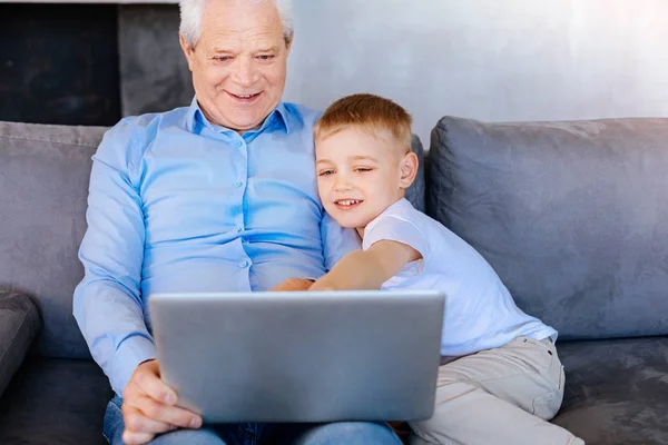 Радостный милый мальчик указывает на экран ноутбука — стоковое фото