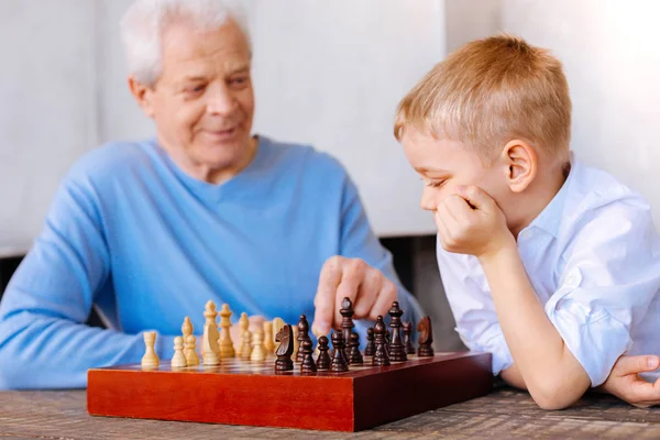 Przyjemne zadumany chłopiec gra gra szachy — Zdjęcie stockowe