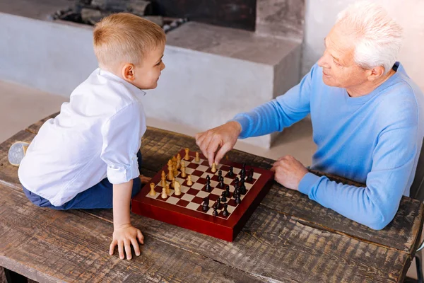 Positiv senior mannen undervisning sonsonen att spela schack — Stockfoto