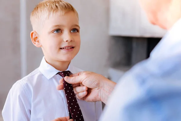 Blij mooie jongen met zijn stropdas vast — Stockfoto