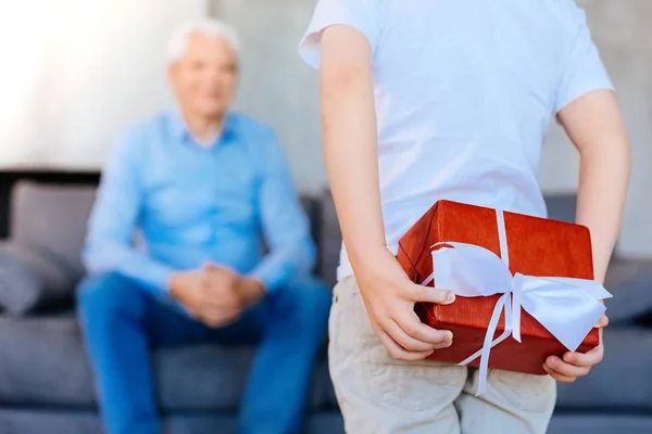 Selective focus of a present being hidden behind the back Stock Photo