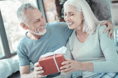 Hediye alma ve sevindirici memnun gri saçlı kadın.