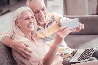 Mutlu üst düzey çift gülüyor ve fotoğraf yapma.