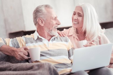 Mutlu yaşlı çift gülüyor ve çay içme.