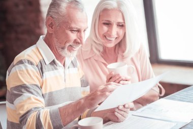 Holding ve belge bakan neşeli sarsılmaz adam.