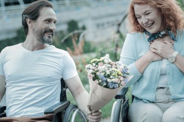 Çiçeklere bakarak olumlu memnun kız