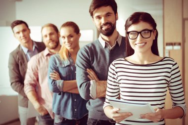 Ekibi önünde duran akıllı neşeli kadın