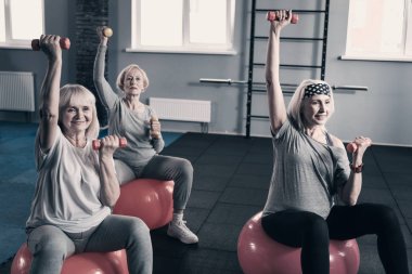 Üst düzey Kadınlar denge topları dumbbells ile egzersiz