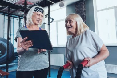 Olgun Bayan arkadaşı gösterilen fitness kulübünde dijital tablet