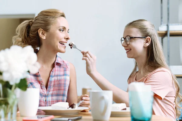 Uśmiechnięte dziewczyny, karmienia jej matka — Zdjęcie stockowe