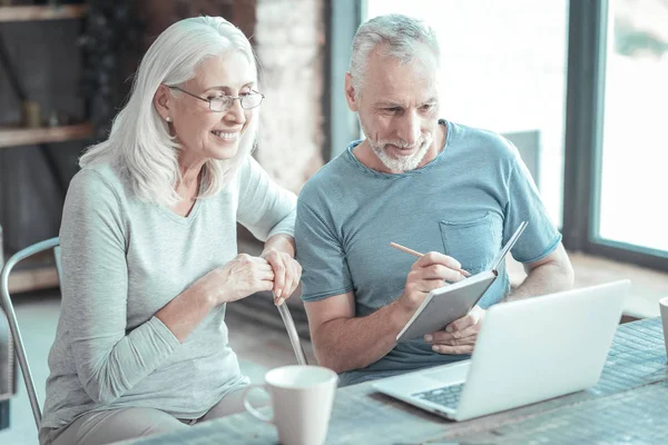 Besetztes Seniorenpaar sitzt und schaut auf den Laptop. — Stockfoto