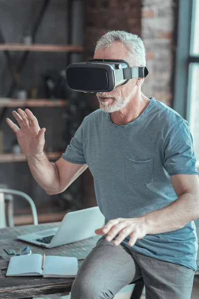 Hombre mayor concentrado degustando gafas VR y dándose la mano . — Foto de Stock