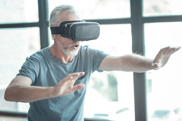 Hombre interesado impresionado tomándose de la mano y degustando gafas VR . — Foto de Stock