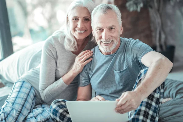 Satisfied aged couple sitting and smiling. — Stock Photo, Image