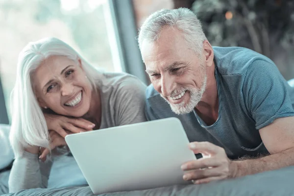 Satisfeito lindo casal rindo e usando o tablet . — Fotografia de Stock