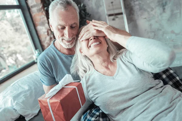 Příjemný milý člověk očima manželky a drží současnosti. — Stock fotografie