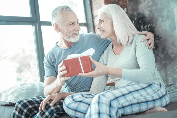 Attento uomo premuroso abbracciare la moglie dando il presente . — Foto Stock