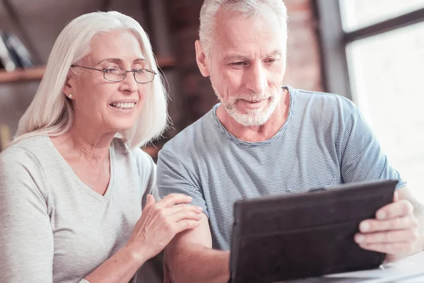 Pareja interesada inteligente sentado y mirando la tableta . — Foto de Stock