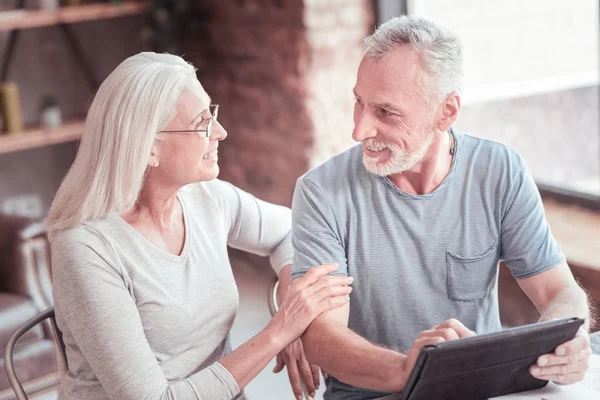 Cute bespectacled woman looking at her husband touching to him.