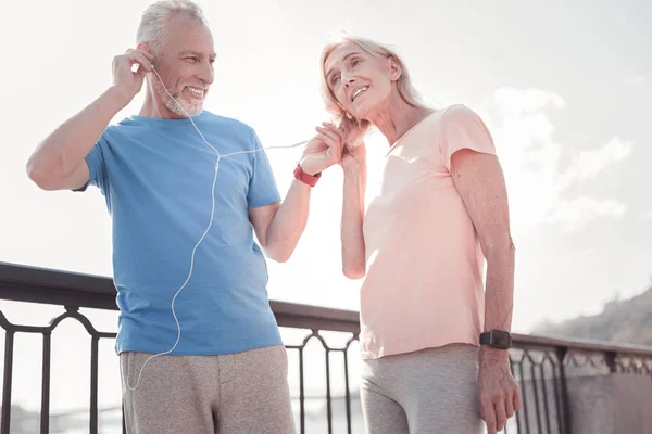 Agréable couple de personnes âgées debout et écoutant de la musique . — Photo