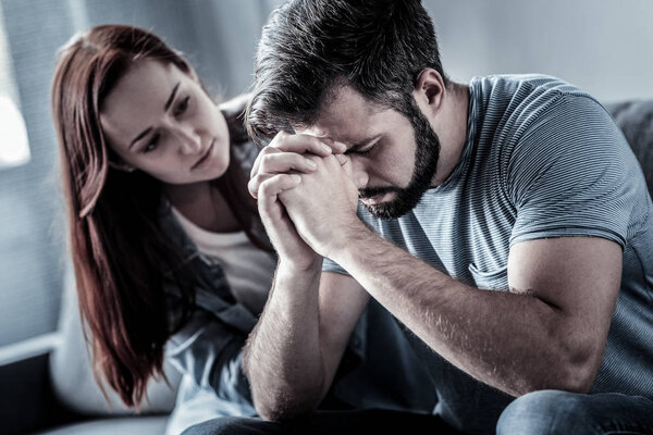 Глубоко расстроенный мужчина держит голову руками закрывая глаза
.