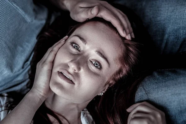 Frustrierte depressive Frau liegt und berührt ihr Gesicht. — Stockfoto