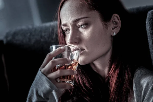 Mujer infeliz frustrada mirando a un lado y bebiendo . — Foto de Stock