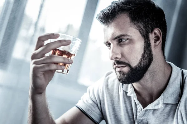 Sad upset man holding and looking at the glass. — Stock Photo, Image