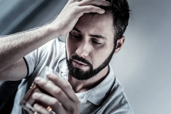 Frustrated unshaken man supporting head and looking at glass. — Stock Photo, Image