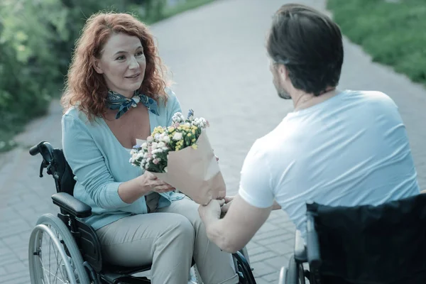 Mujer discapacitada tomando ramo de flores — Foto de Stock